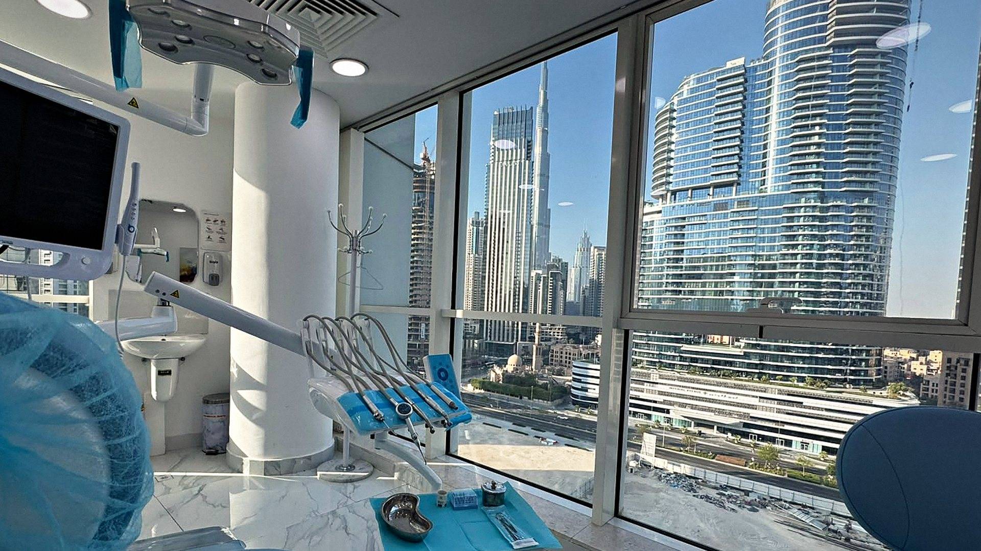 A dental treatment room at Murano Polyclinic, with the Burj Khalifa and Business Bay through the window